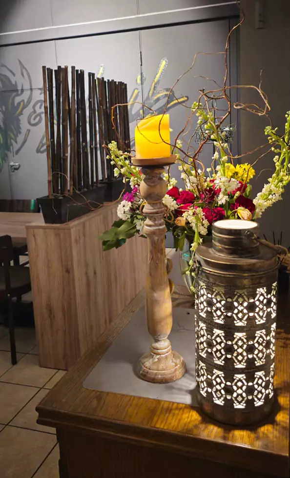 Dekoration: Laterne, Vase mit Blumen und einer Kerze